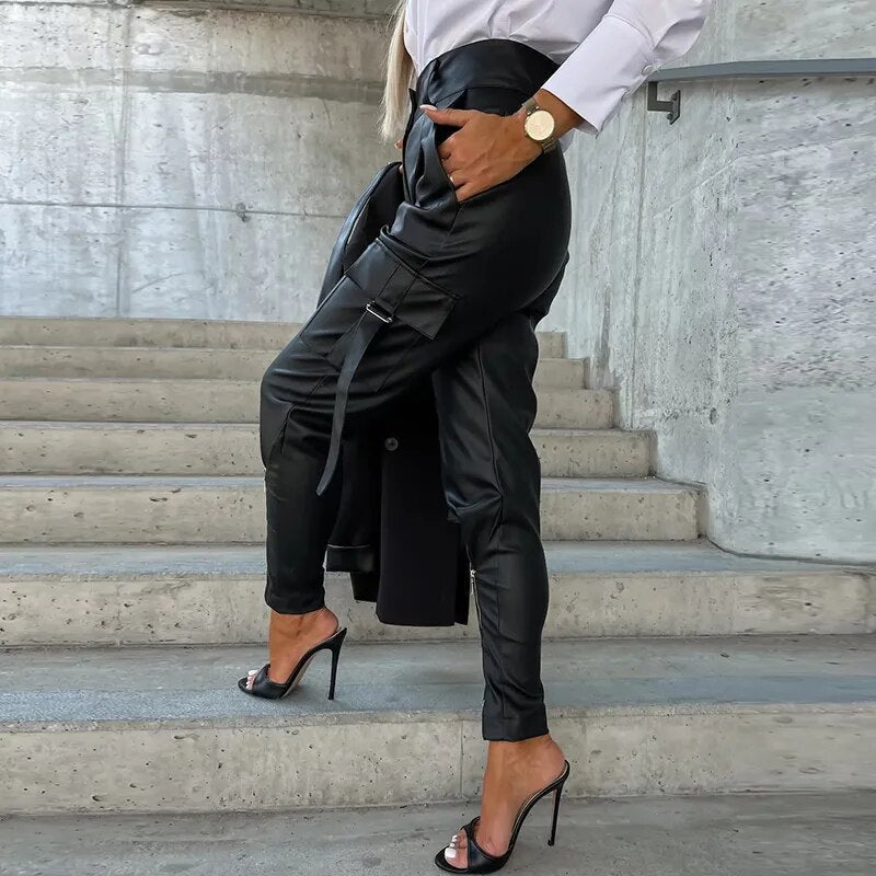 Frau in schwarzer Lederhose und High Heels auf Treppe, modisch, elegant, urbaner Stil.