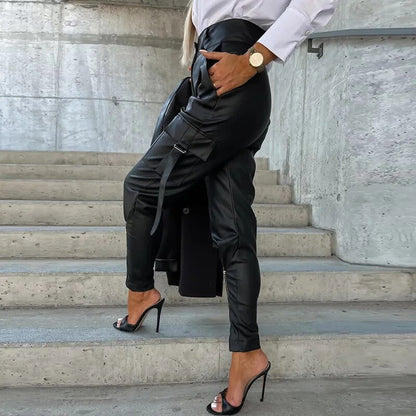 Frau in schwarzer Lederhose und High Heels auf Treppe, modisch, elegant, urbaner Stil.