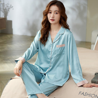 Frau in hellblauem Seidenpyjama sitzt auf Bett, elegantes Nachtwäsche-Design.