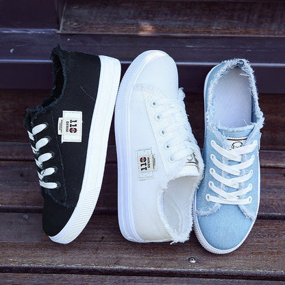 Drei Paar Sneaker aus Stoff in Schwarz, Weiß und Blau mit Fransen, lässige Damenmode.