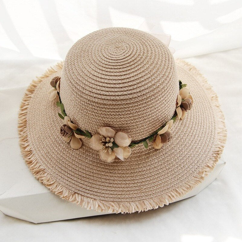 Beiger Damen-Sonnenhut aus Stroh mit Blumenverzierung, ideal für Sommermode und Strand.