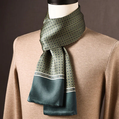 Grön halsduk med små cirkelmotiv i beige, smal bård och slät grön kant, draperad på skyltdocka med beige tröja. 8