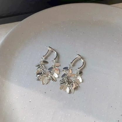 Silberne Creolen Ohrringe mit Blattanhängern, modisches Schmuckdesign, elegantes Accessoire.