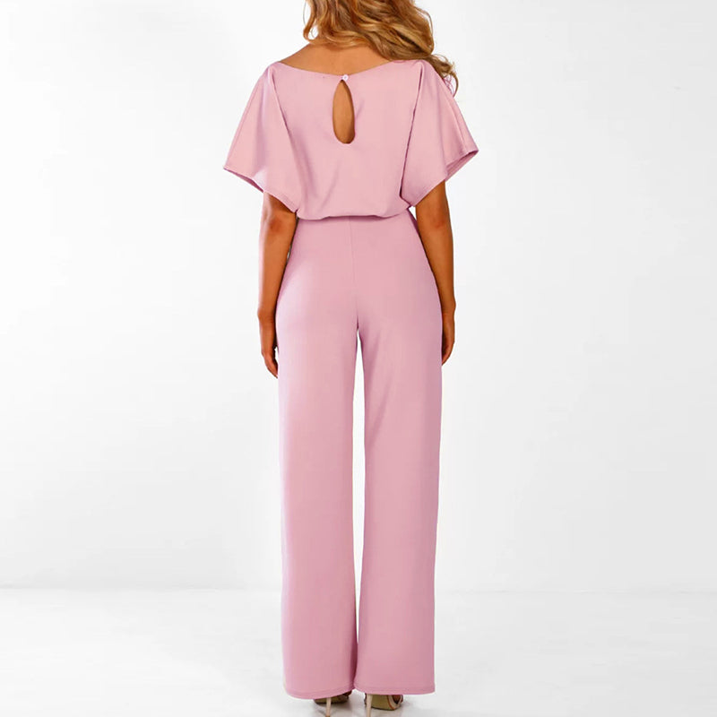 Frau in rosa Jumpsuit mit weitem Bein, Rückenausschnitt, elegantes Design, Modekleidung.