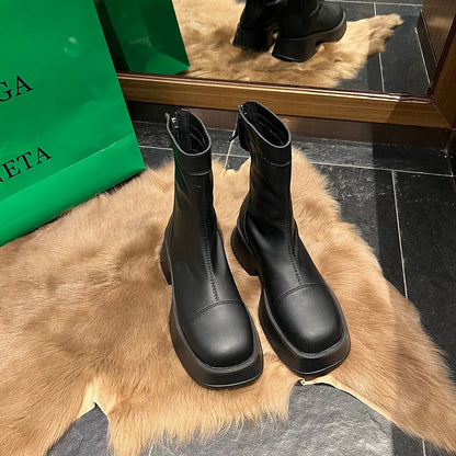 Schwarze Lederstiefel mit Plateauabsatz auf Fellteppich vor Spiegel, Modeaccessoire.