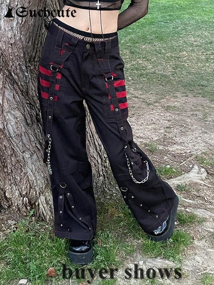 Schwarze Gothic-Hose mit roten Streifen, Ketten und Nieten, Damenmode, Outdoor-Fotografie.