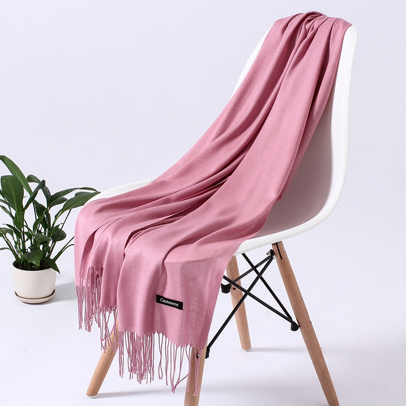 Rosa Kaschmirschal auf Stuhl, weiches Material, modisches Accessoire, ideal für Damen.