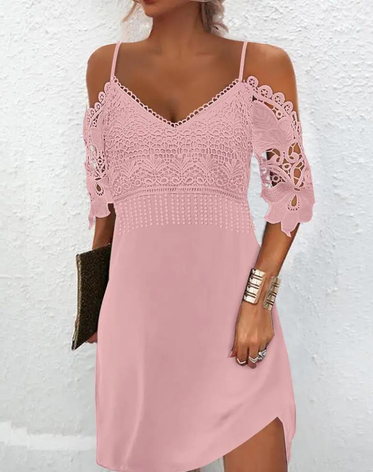 Frau in rosa Spitzenkleid, schulterfrei, mit Clutch und Armband vor weißer Wand.