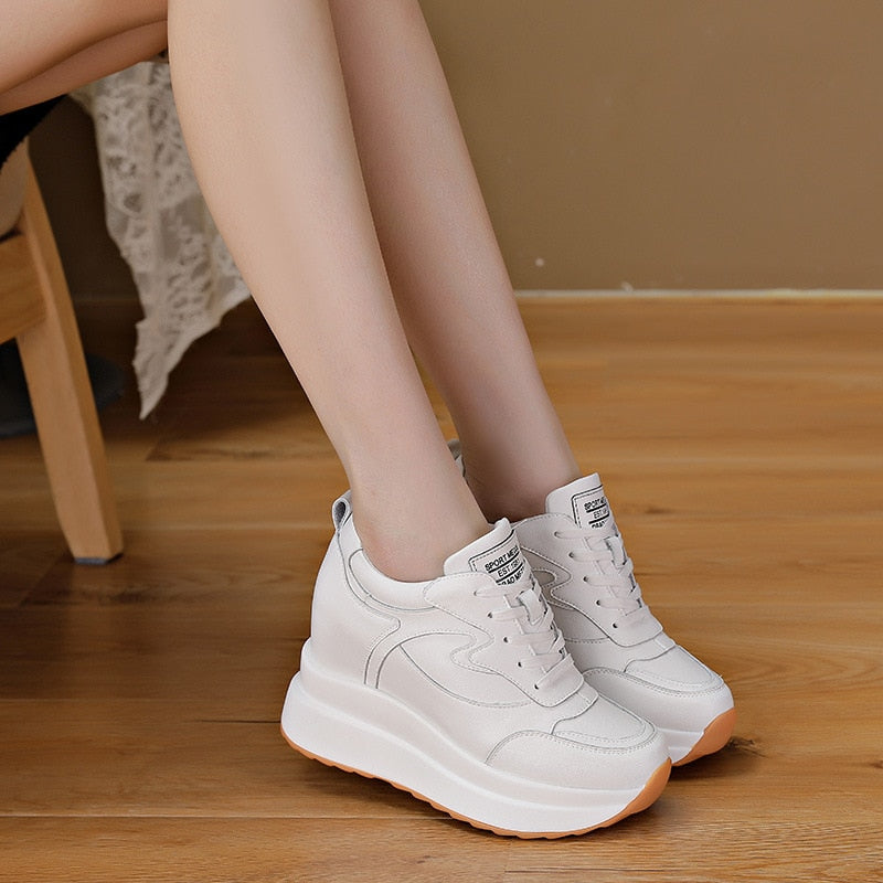 Weiße Damen-Sneaker mit Plateau, Leder, modisch, bequem, auf Holzboden.