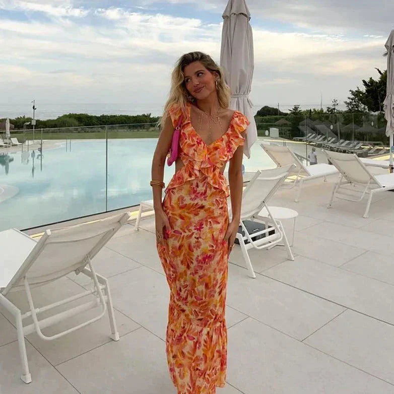 Frau im langen, orange-gelben Sommerkleid am Pool, elegante Freizeitmode, Urlaubskleidung.