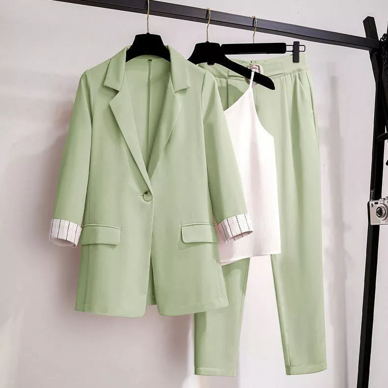 Hellgrüner Damenanzug mit Blazer, Hose und weißem Top, elegantes Büro-Outfit.