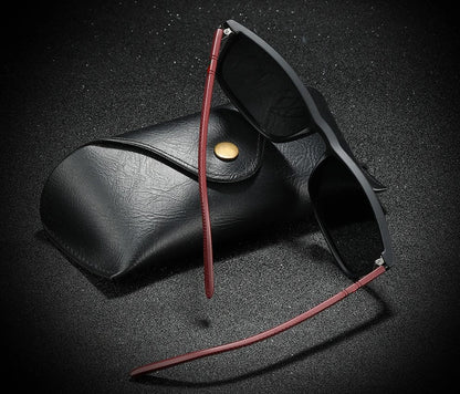 Schwarze Sonnenbrille mit rotem Bügel und Etui, modisches Accessoire, UV-Schutz.