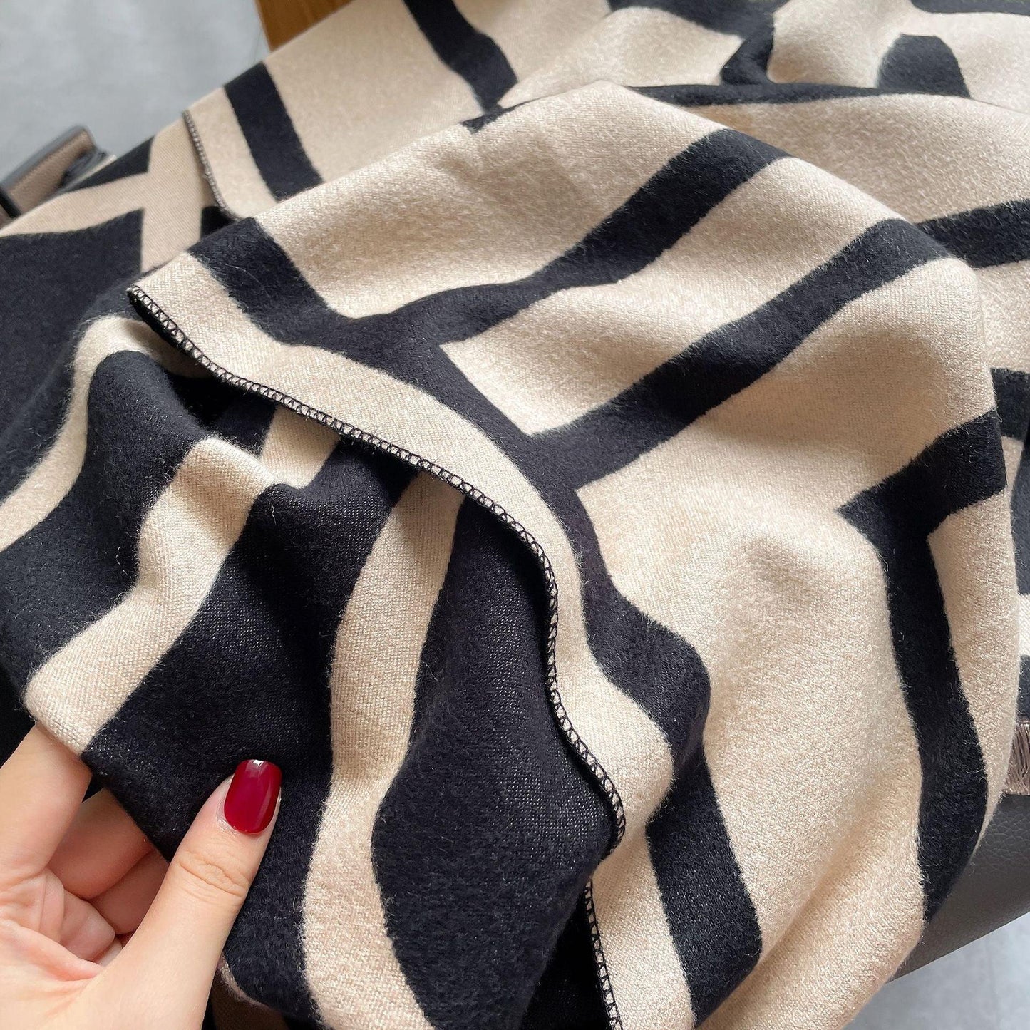 Schwarz-beige gestreifter Wollschal, weiches Material, modisches Accessoire, Damenmode.