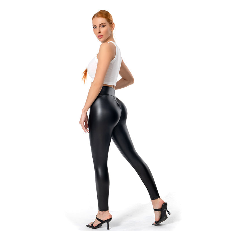 Frau in schwarzer Lederleggings und weißem Top, modisch, elegant, High Heels, Studioaufnahme.
