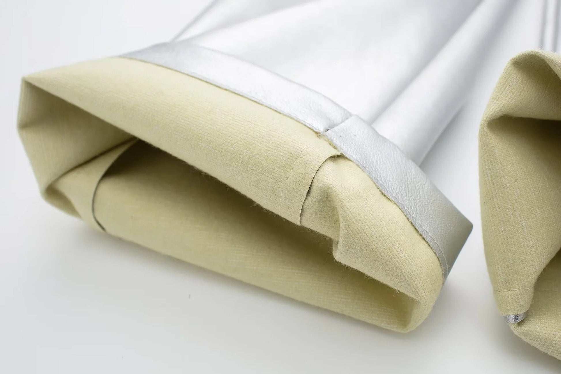 Beige und silberne Hitzeschutzmanschette aus Stoff für industrielle Anwendungen.