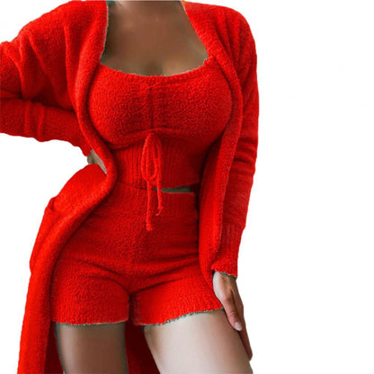 Frau in rotem Strick-Set: Cardigan, Top, Shorts. Modetrend, bequeme Damenbekleidung.