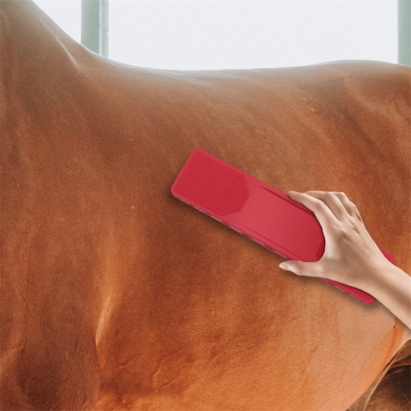 Rote Pferdebürste aus Kunststoff, ergonomisch, für Fellpflege, Hand hält Bürste am Pferd.