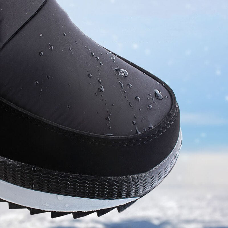 Schwarzer wasserdichter Winterschuh mit rutschfester Sohle im Schnee.