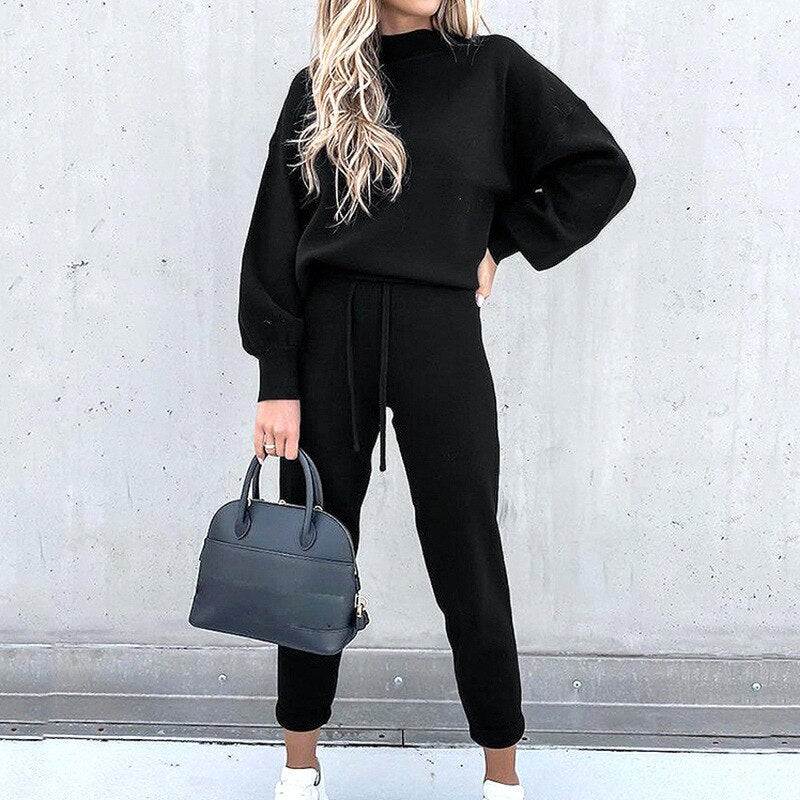 Frau in schwarzem Jumpsuit mit Tasche, lässige Mode, Herbst-Outfit, Streetstyle.