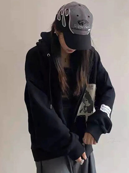 Frau in schwarzem Hoodie und Baseballkappe mit Flammen-Design, lässige Streetwear-Mode.