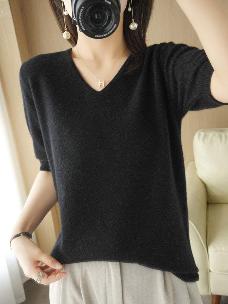 Frau trägt schwarzen V-Ausschnitt Pullover, weiches Material, modisch, lässiger Stil.