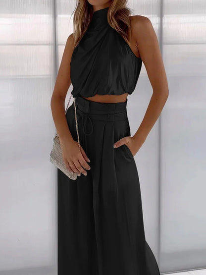 Frau in schwarzem ärmellosen Kleid mit silberner Handtasche, elegantes Abendoutfit.