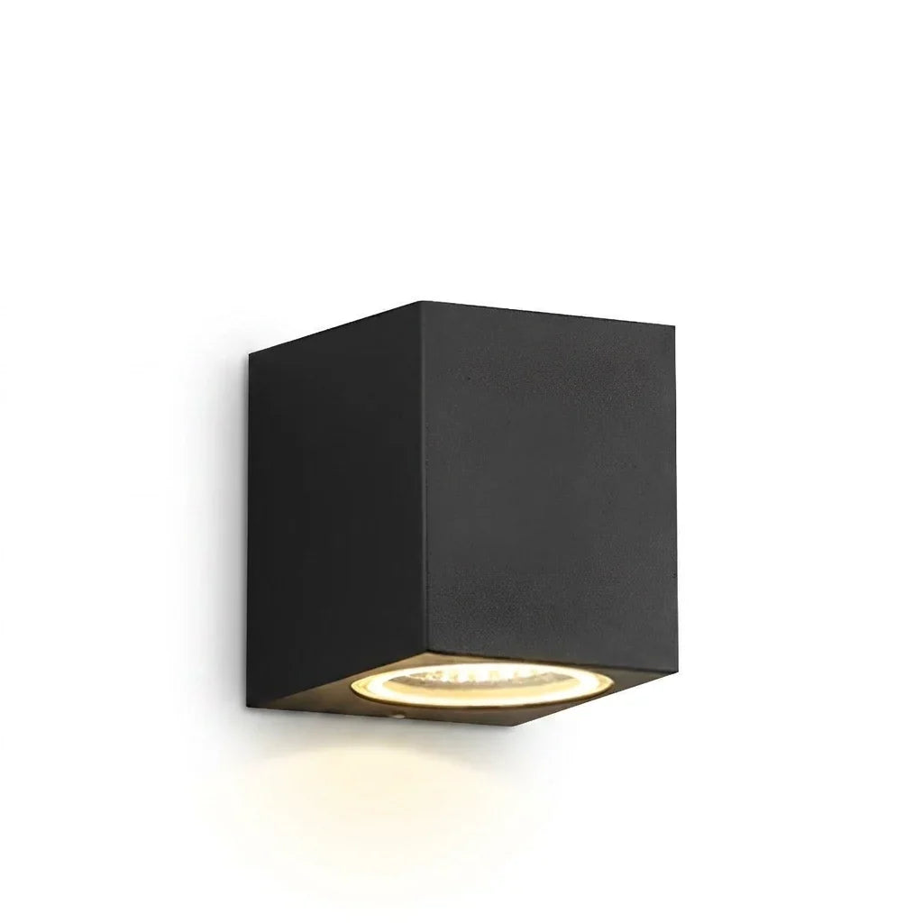 Svart kubformad vägglampa med enkel nedåtriktad lysande lampa, fotograferad mot vit bakgrund 1