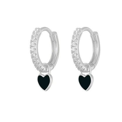 Silberne Creolen mit schwarzen Herzanhängern und Kristallverzierung, eleganter Schmuck.