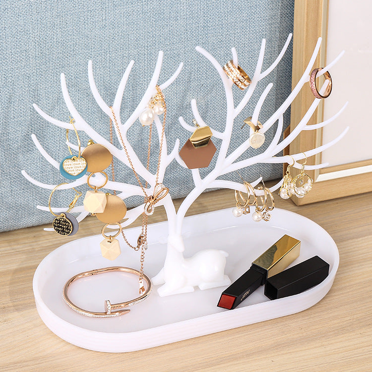 Weißer Schmuckhalter in Hirschform mit Schmuck und Lippenstift, dekorativer Organizer.