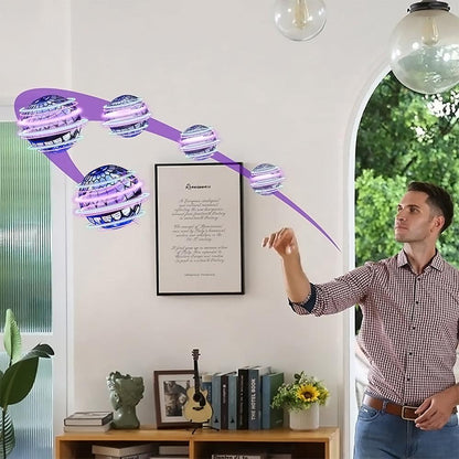 Mann wirft lila LED-Flugspielzeug im Wohnzimmer, moderne Unterhaltung, Indoor-Drohne.