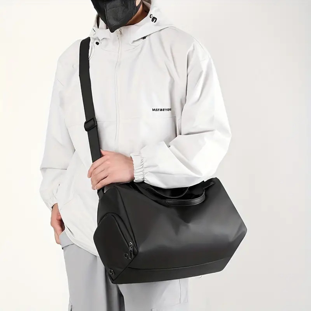 Schwarze wasserdichte Sporttasche mit Schuhfach, getragen von Person in weißer Jacke.