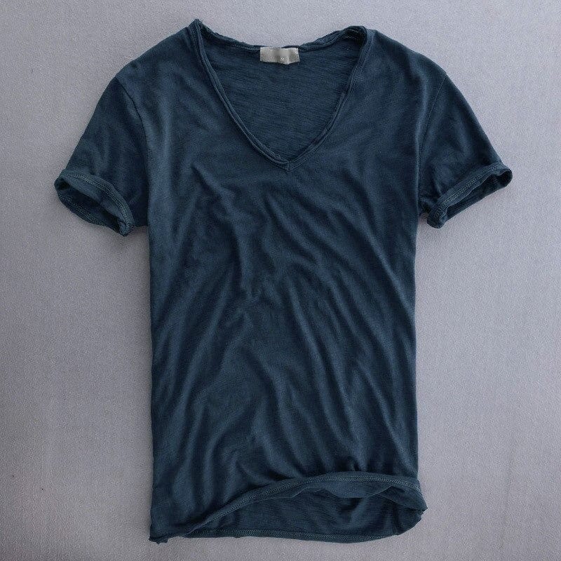 Marinblå kortärmad v-ringad t-shirt liggande platt framifrån, med uppvikta ärmar och mjukt texturerat tyg. 5