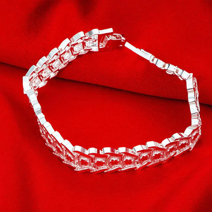 Silbernes Armband auf rotem Hintergrund, elegantes Schmuckdesign, modisches Accessoire.