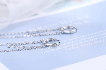Silberne Creolen mit Kette, elegantes Design, Schmuck für Damen, modisch und stilvoll.