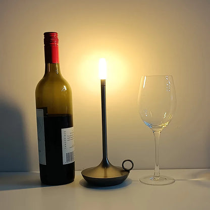 Moderne Tischlampe LED, dimmbar, USB-C, neben Weinflasche und Weinglas, warmweißes Licht.