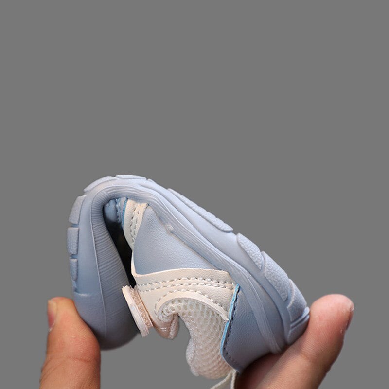 Hellblauer, flexibler Babyschuh aus Leder und Mesh, ideal für Kleinkinder, handgehalten.