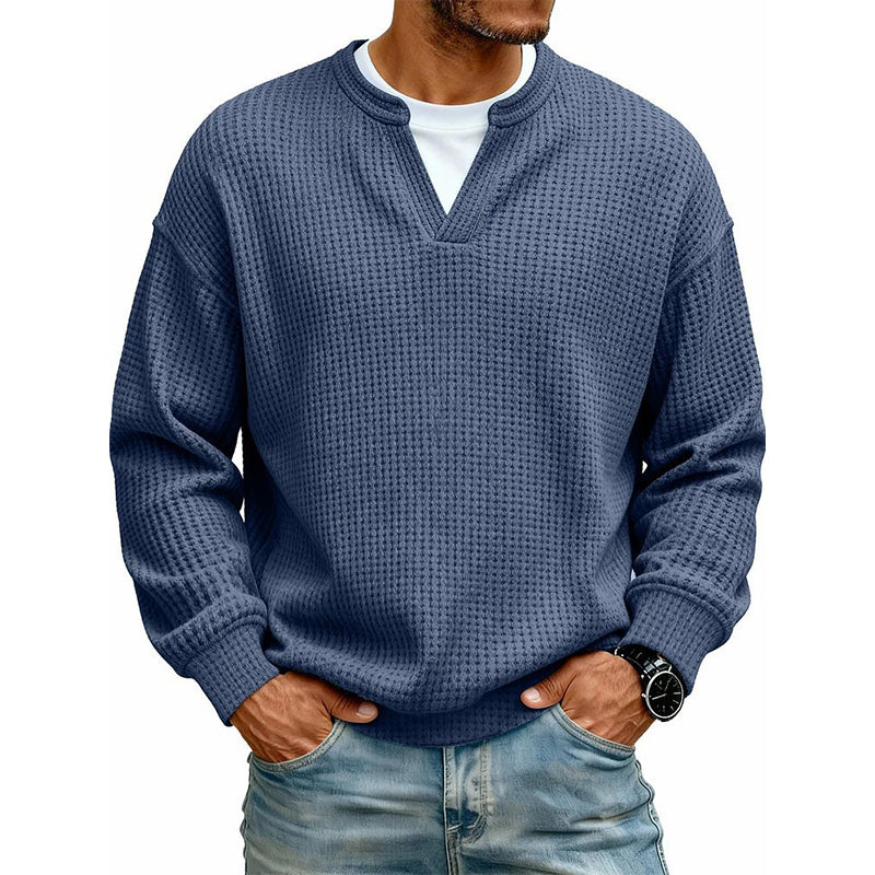 Mörkblå våffelstickad tröja med lång ärm på modell, vit t-shirt under kragen, med armbandsur 5