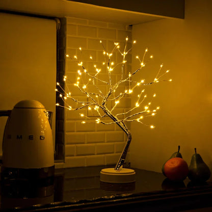 Tänd trädlampa i ett kök framför kakelvägg, bredvid en vattenkokare och några frukter 5