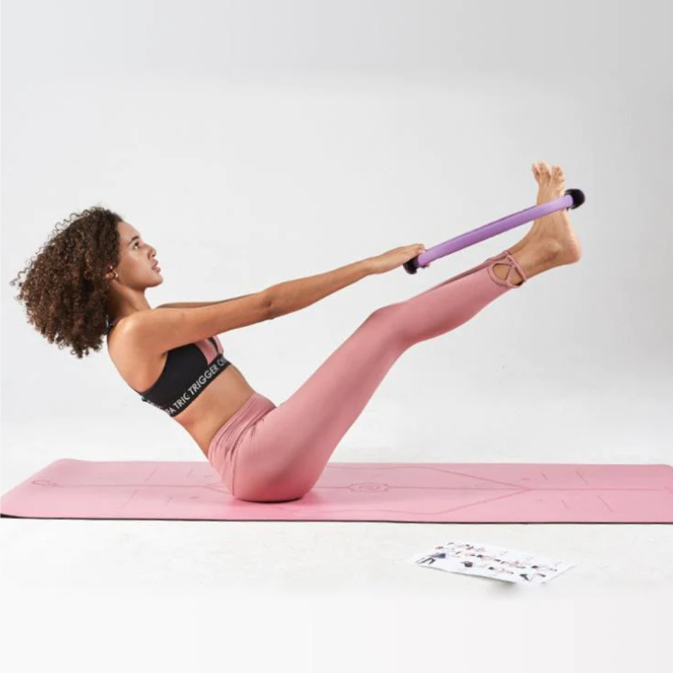 Frau trainiert mit Pilates-Stab auf rosa Yogamatte, Sportbekleidung, Fitnessübung, Heimtraining.