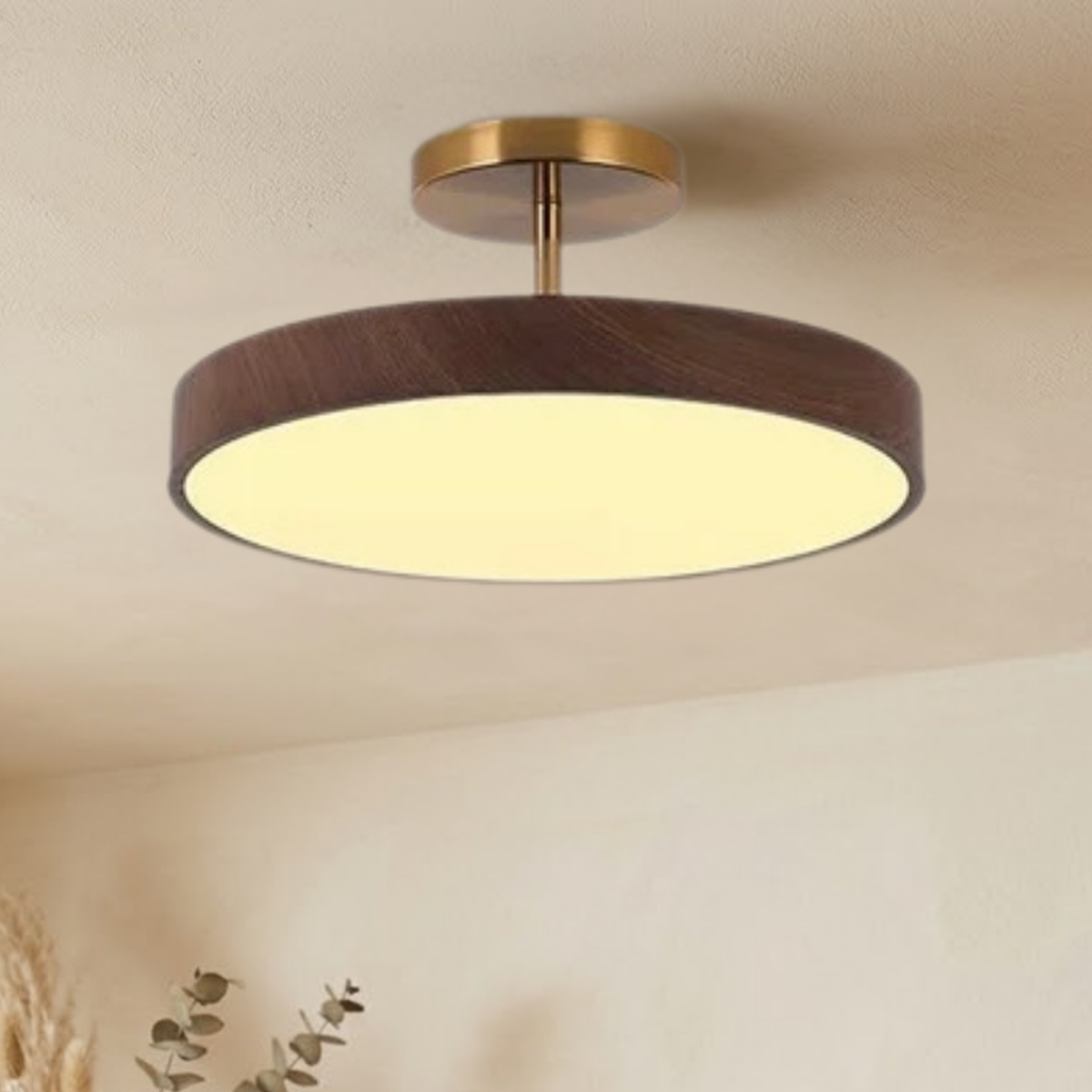 Tänd lampa med mörk trälook och guldfärgat fäste i taket, sedd snett underifrån med torkade växter nedtill i bild. 3