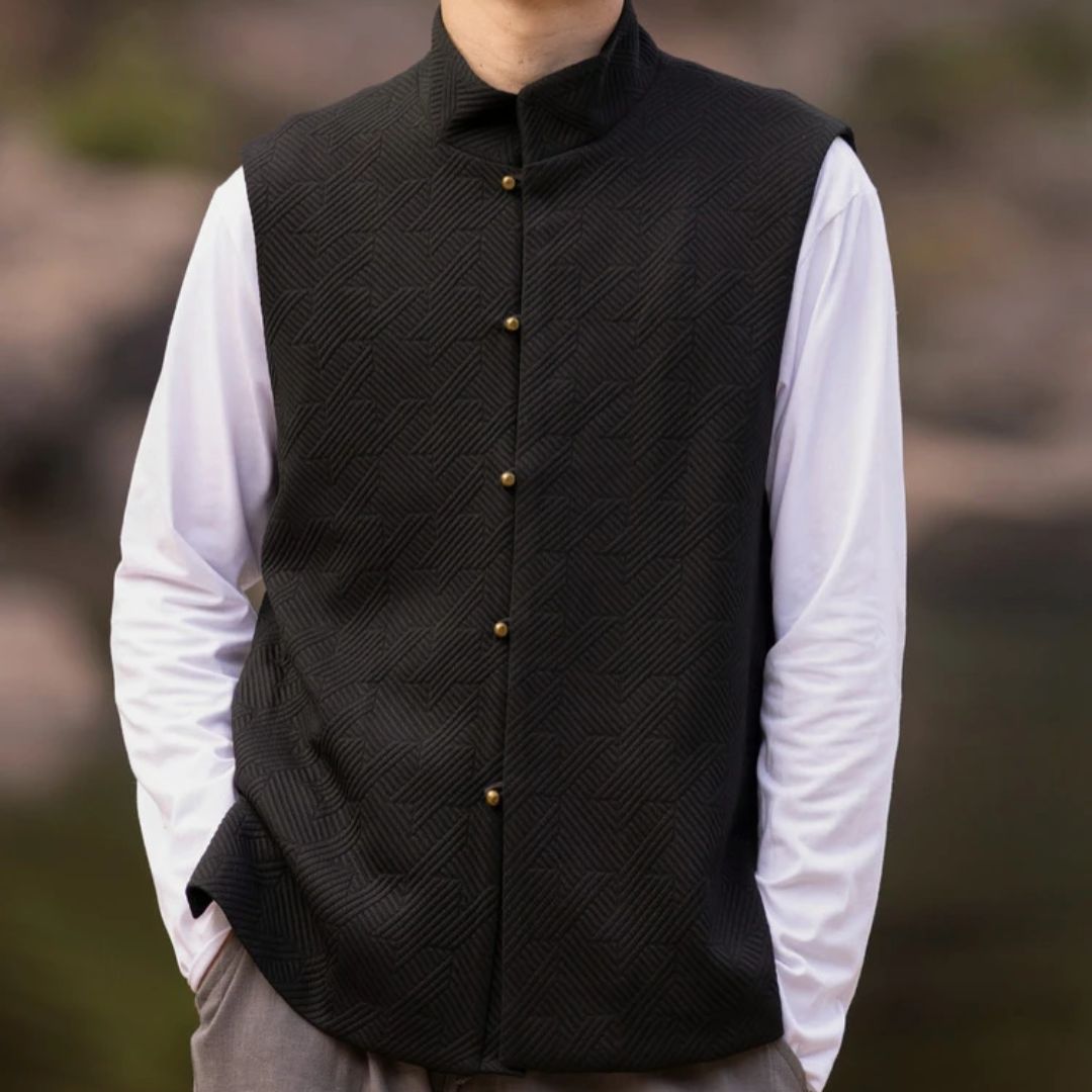 Schwarze Herrenweste mit Stehkragen, Knöpfen, über weißem Hemd, elegantes Design.