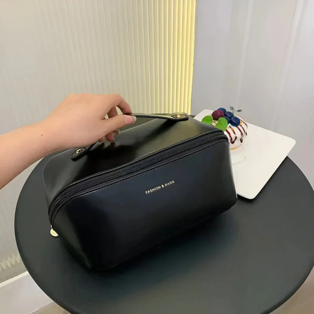Schwarze Kosmetiktasche aus Leder auf Tisch, Hand hält Griff, moderne Inneneinrichtung.