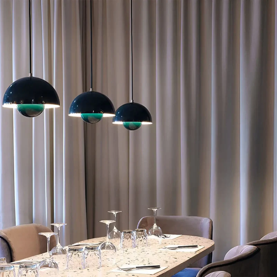 Drei schwarze Pendelleuchten über Esstisch, moderne Innenbeleuchtung, elegantes Design.