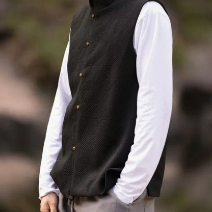 Mann in schwarzer Steppweste und weißem Langarmshirt, Outdoor-Mode, Herbstbekleidung.