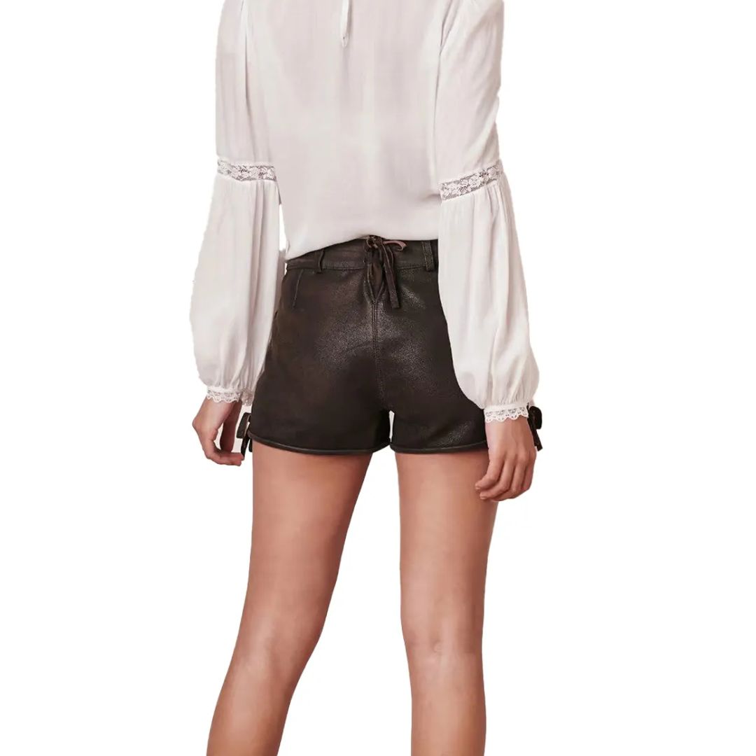 Frau in weißer Bluse und schwarzen Leder-Shorts, Rückansicht, modische Damenbekleidung.