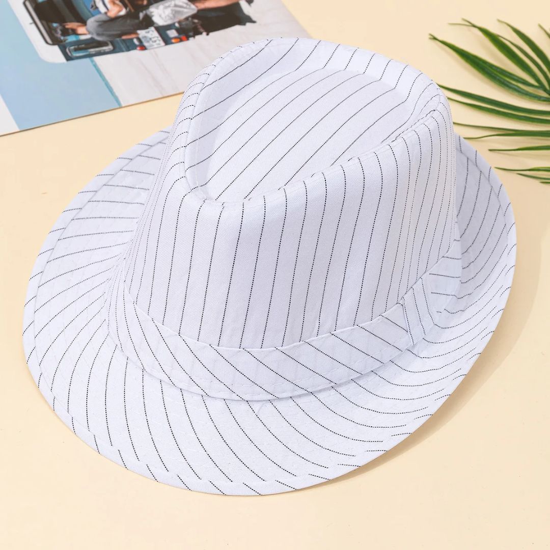 Weißer gestreifter Fedora-Hut aus Baumwolle auf beigem Hintergrund, modisches Accessoire.