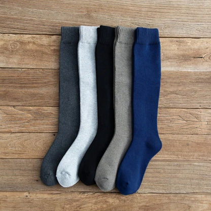 Fünf Paar bunte Kniestrümpfe aus Baumwolle auf Holzboden, ideal für Herbstmode.