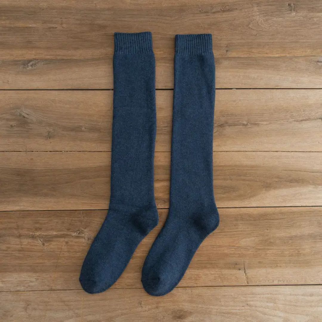 Dunkelblaue Kniestrümpfe aus Baumwolle auf Holzboden, bequeme Socken für Damen und Herren.