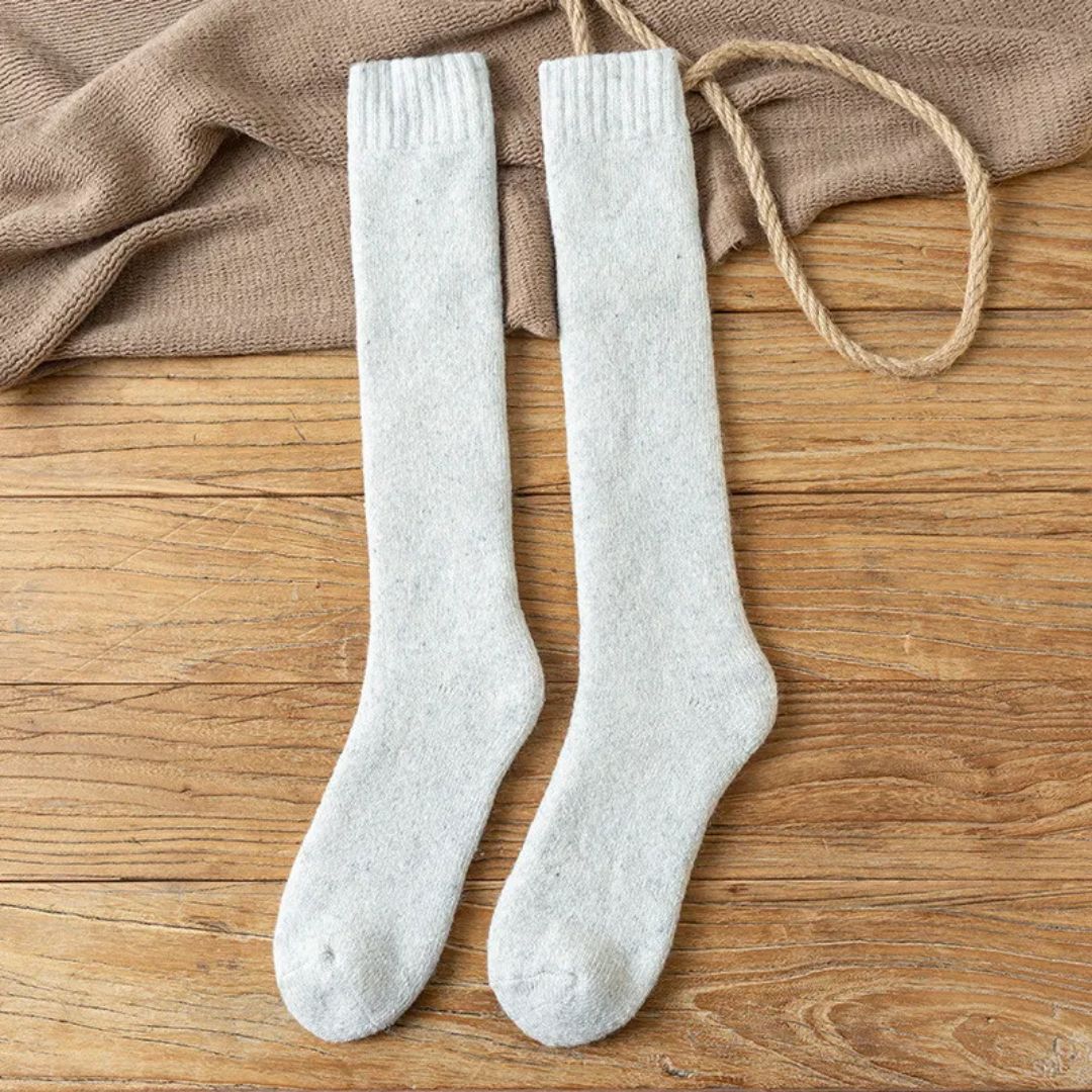 Damen Kniestrümpfe aus Wolle, beige, warm, bequem, auf Holzboden mit Seil und Decke.