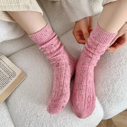 Rosa gestrickte Wollsocken, gemütlich, warm, Damenmode, Winteraccessoire, auf weißem Sofa.